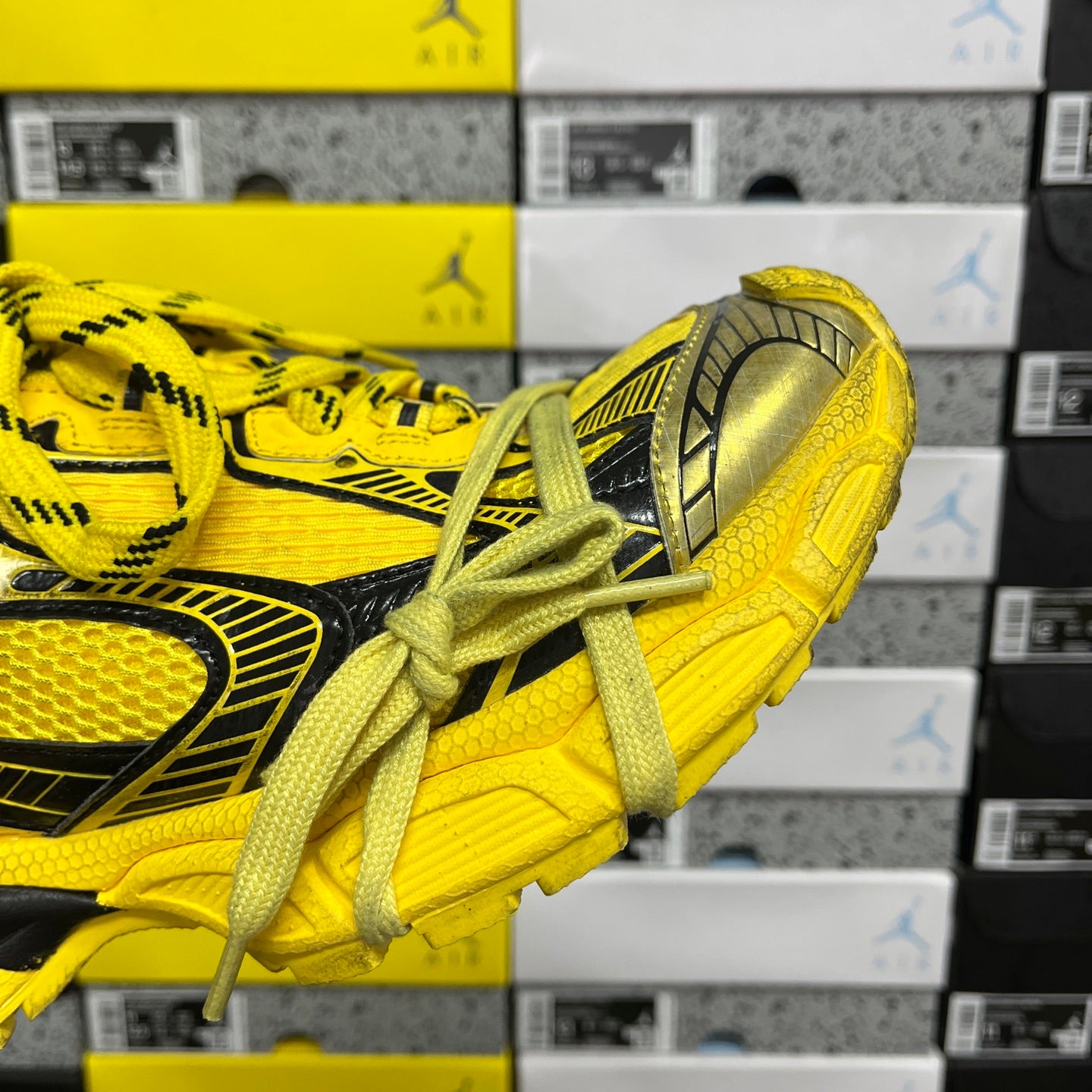 Yellow sneakers with black side stripe, metallic heel cap, lace-up design