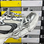 White Balenciaga sneakers, side view with black piping accents and lace-up front.