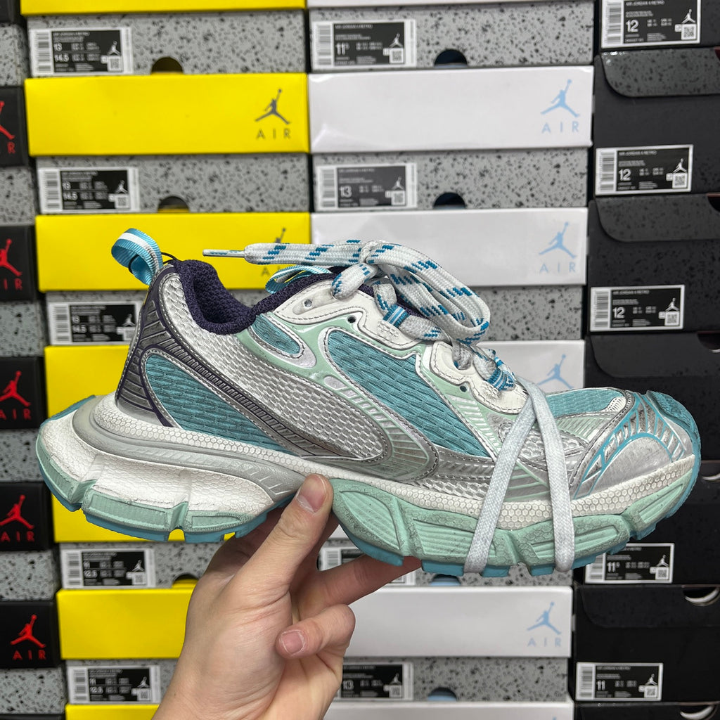 Balenciaga unisex sneaker 3/4 view in white, teal, and silver with blue-striped laces