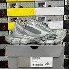 Gray mesh sneakers with lace-up front, layered panels, and cushioned midsole
