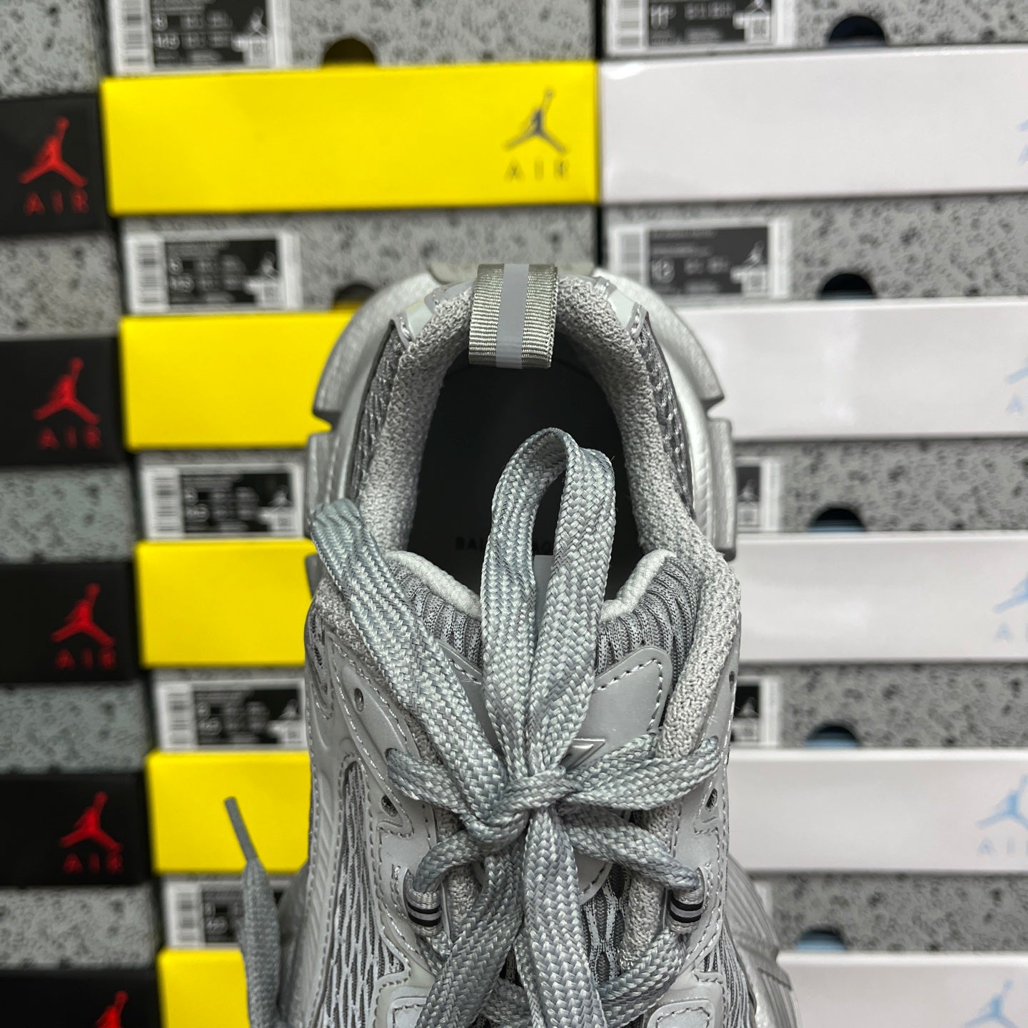 Gray mesh sneaker with open collar and lace-up front, view from inside heel