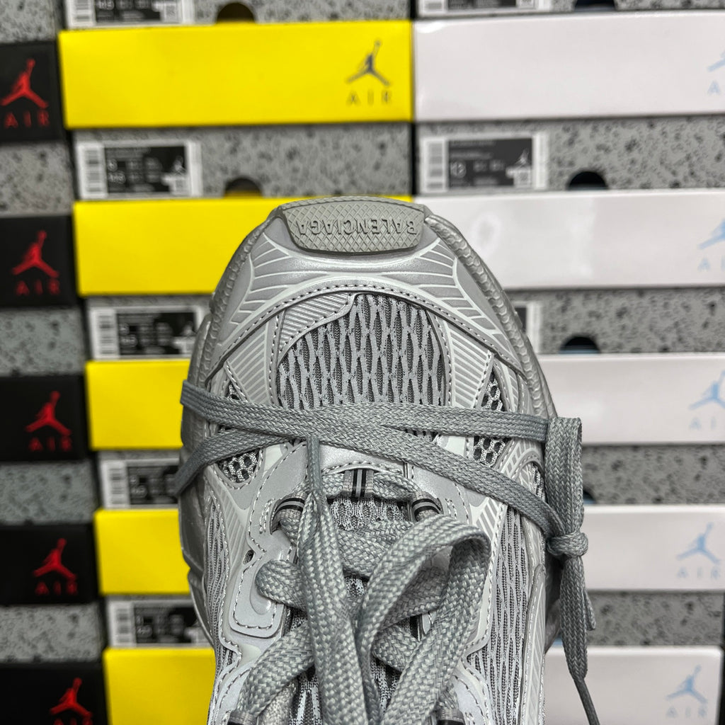Gray mesh sneaker upper with lace loops and woven textile at the heel
