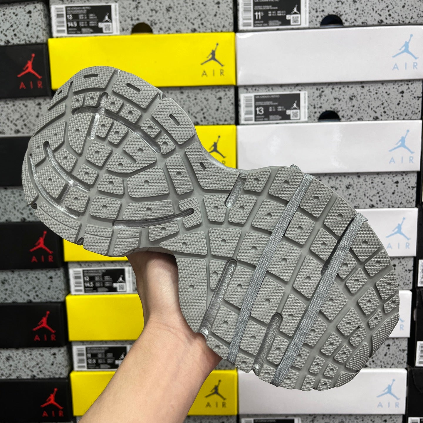 Gray mesh sneaker outsole with detailed tread pattern and cushioned side wall