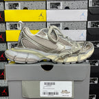 Silver-gray lace-up running sneaker with textured overlays and thick, comfort sole.
