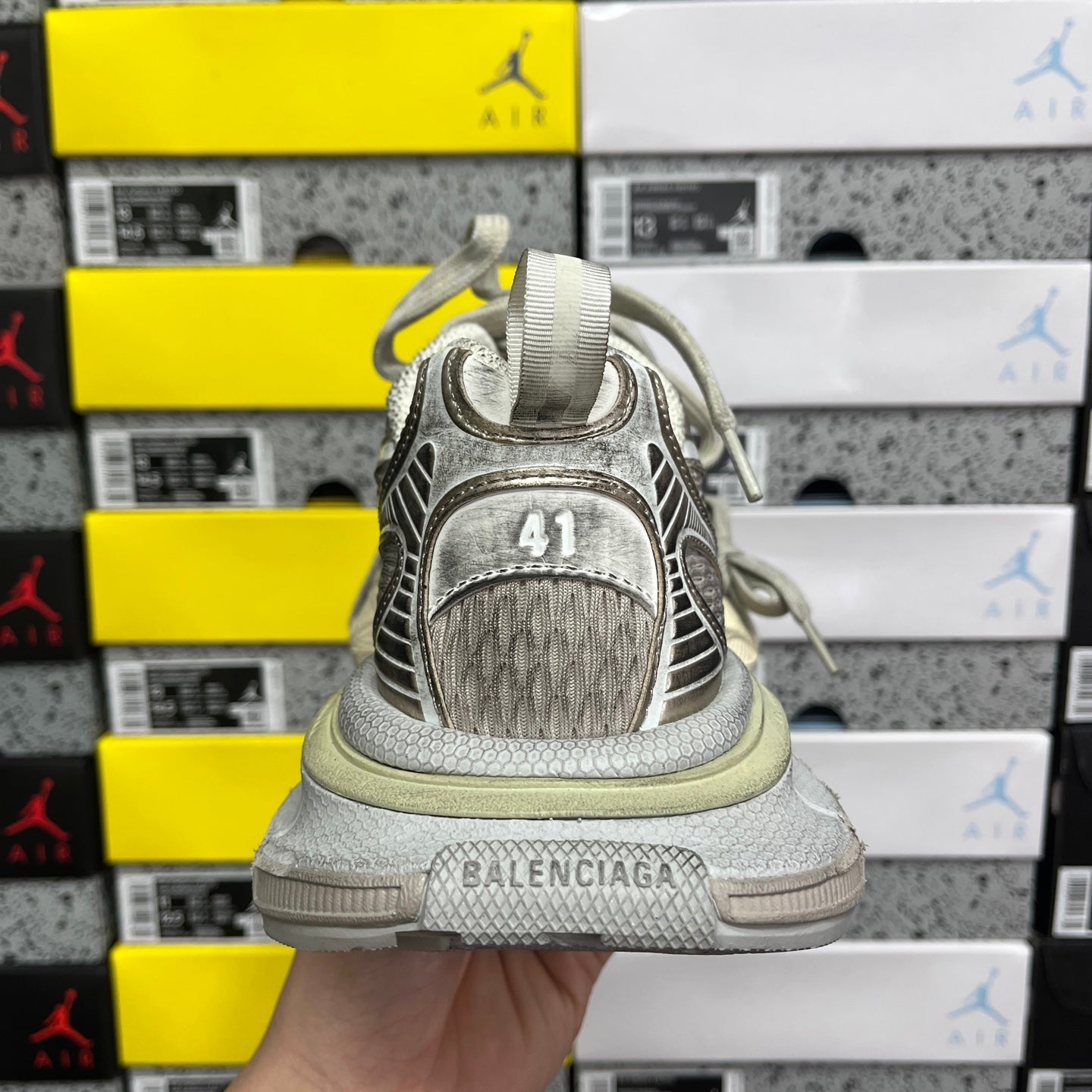 Silver-gray sneaker heel with BALENCIAGA text and textured back panel.