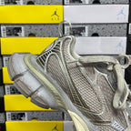 Silver-gray lace-up sneaker with padded collar and sculpted, cushioned sole.