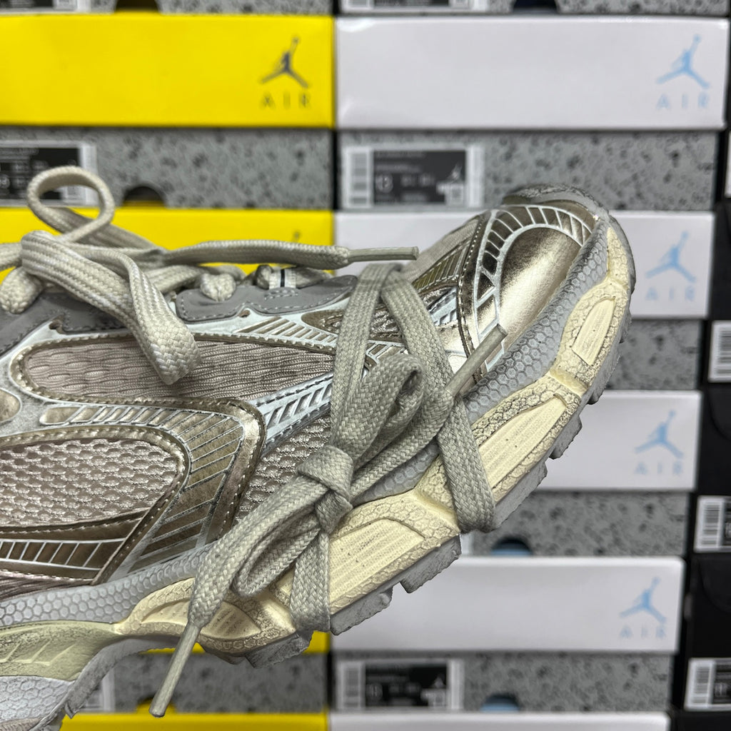 Silver-gray lace-up sneaker with padded collar and ribbed side panel detail.