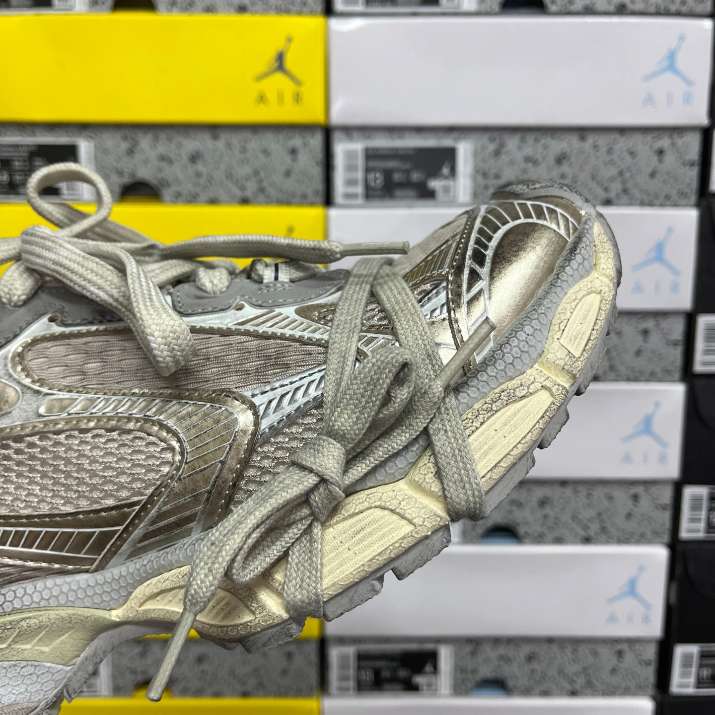 Silver-gray lace-up sneaker with padded collar and ribbed side panel detail.