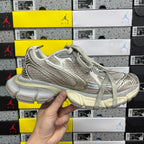Silver-gray lace-up running sneaker with textured overlays and light-toned sole.