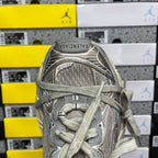 Silver-gray lace-up sneaker tongue with logo patch and mesh-textured upper.