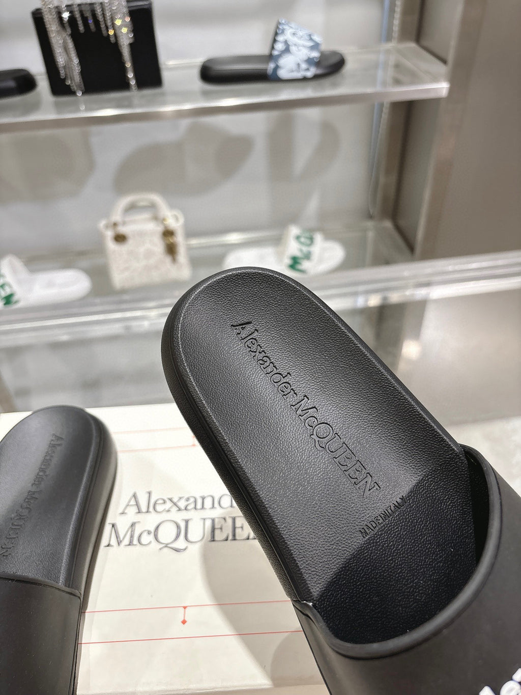 Black Alexander McQUEEN slide sandal footbed with logo text, close-up