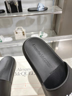 Black Alexander McQUEEN slide sandal footbed with logo text, close-up