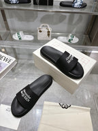 Black Alexander McQUEEN slide sandals with wide logo strap on display