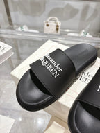 Black Alexander McQUEEN slide sandal with wide strap and logo, close-up