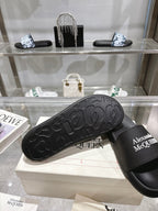 Black Alexander McQUEEN slide sandal showing textured outsole tread