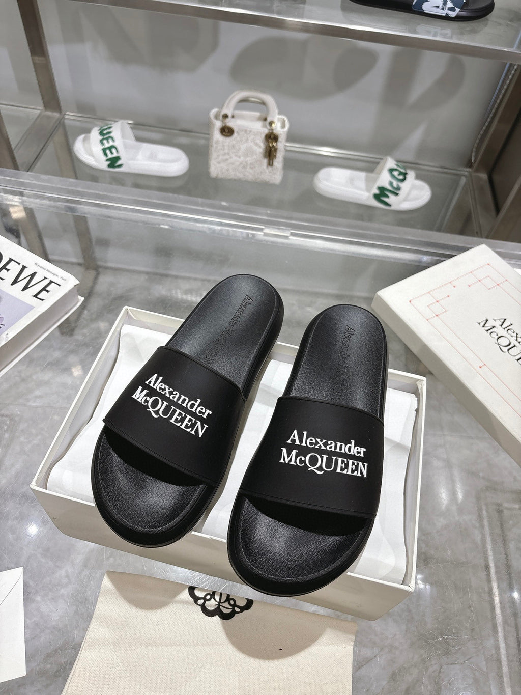 Black Alexander McQUEEN slide sandals with wide logo strap, pair view