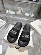 Black Alexander McQUEEN slide sandals with wide logo strap, pair view