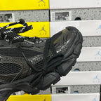 Black Balenciaga sneaker side profile with laces, straps, and embossed textures