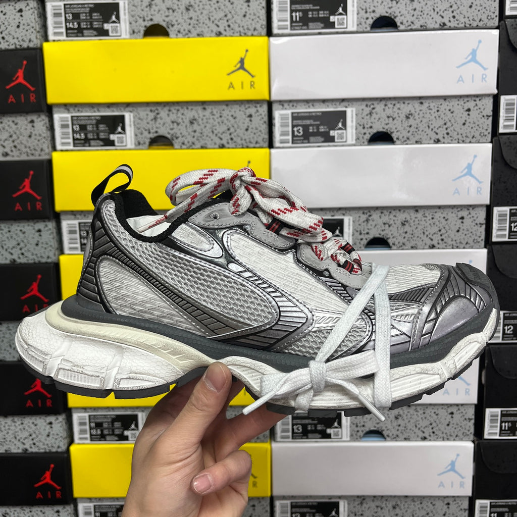 Chunky mesh sneaker with white laces, grey and black panels, red accent stitching