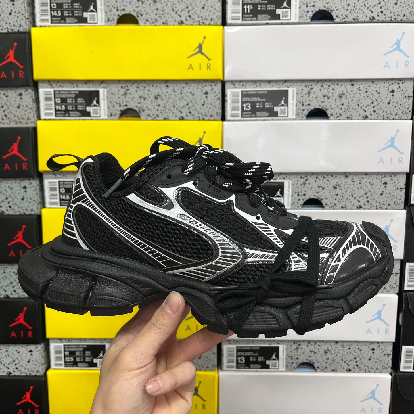 Black and gray athletic sneaker with white side panels, mesh upper, and black laces