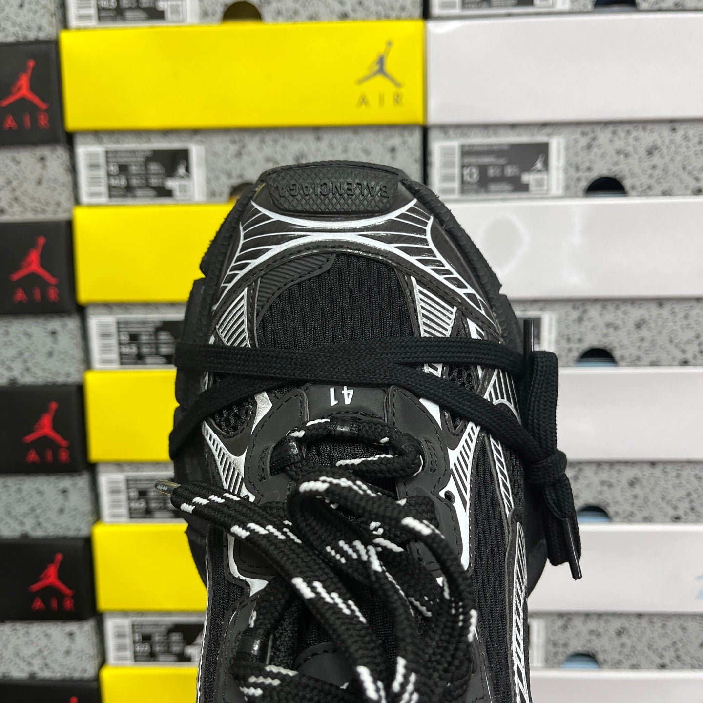 Black sneaker tongue and laces with white ribbed overlay and textured collar