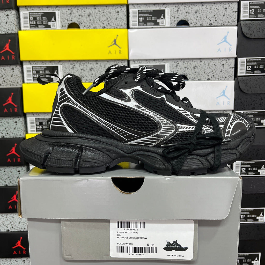 Black athletic sneaker with white side stripe trim and thick black sole