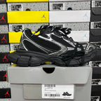 Black athletic sneaker with white side stripe trim and thick black sole