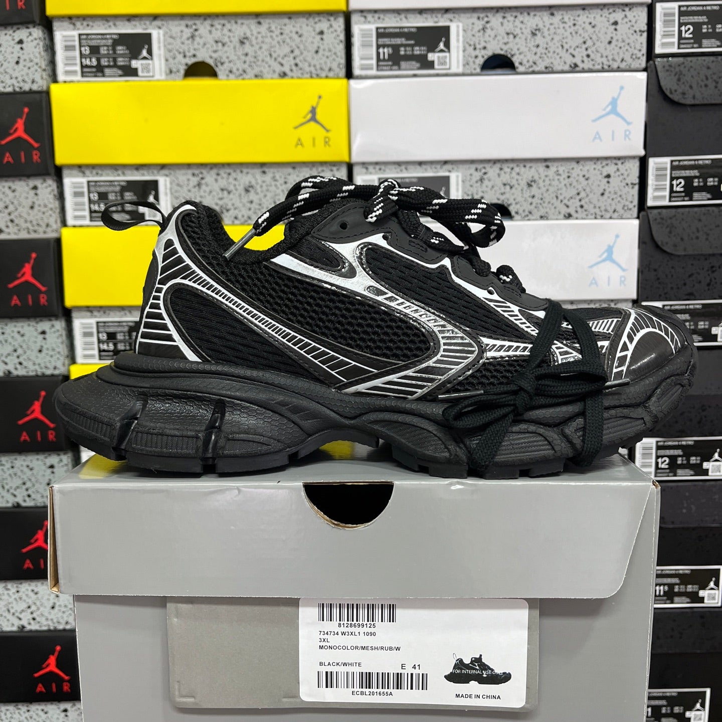 Black athletic sneaker with white side stripe trim and thick black sole