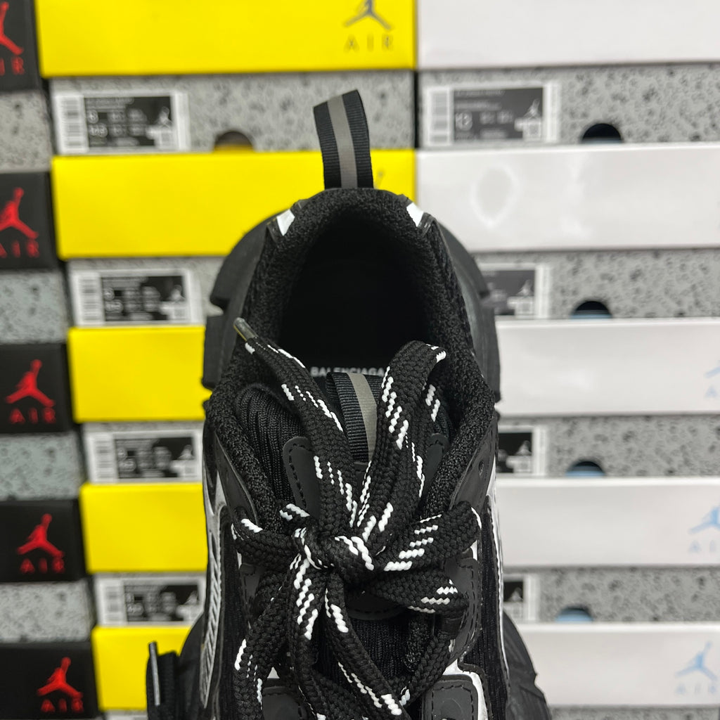 Black sneaker collar and tongue with woven texture and braided white lace accents