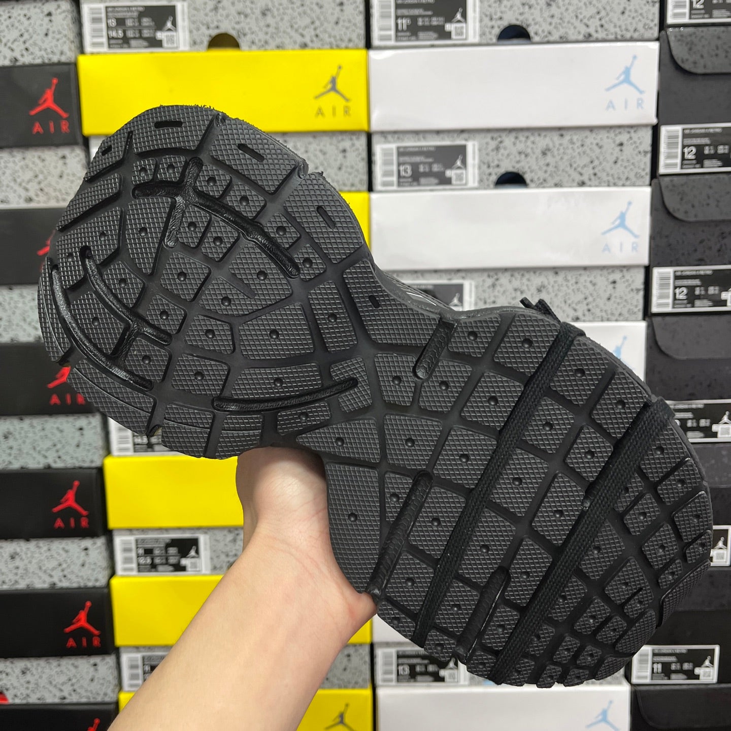 Black sneaker outsole with grid traction pattern and raised rubber tread blocks