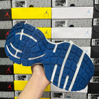 Blue rubber outsole with white traction stripes under the sneaker