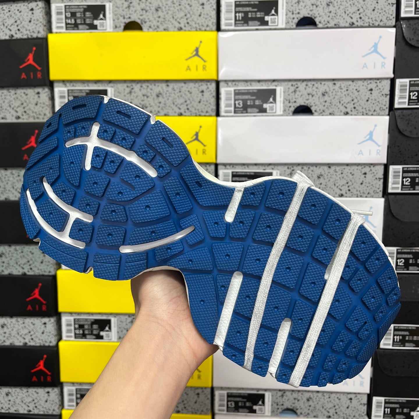 Blue rubber outsole with white traction stripes under the sneaker