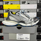 Gray and black lace-up sneaker with white laces, blue detailing, and chunky sole