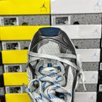 Gray and black sneaker toe view with blue-striped laces and textured mesh panels