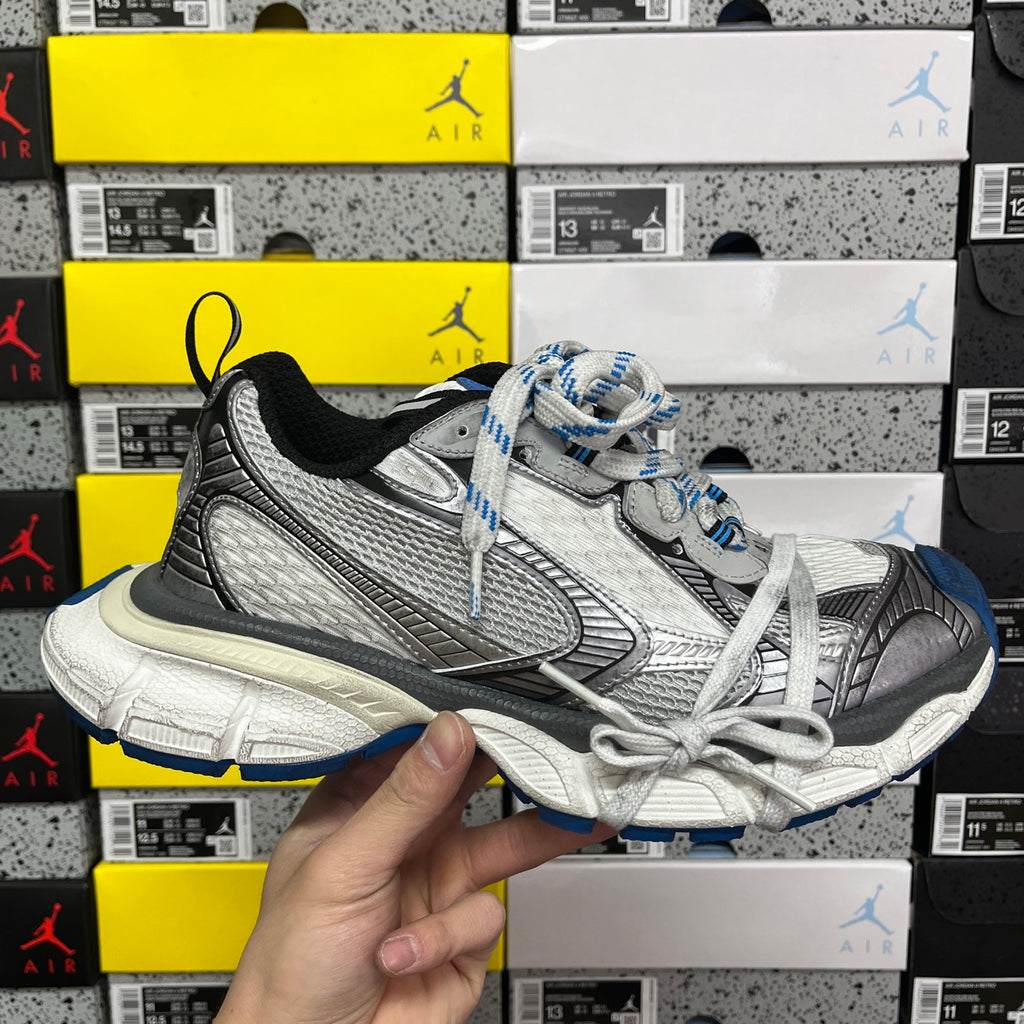 Gray and black lace-up sneaker with blue accents and textured side panels