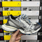 Gray and black lace-up sneaker with blue accents and textured side panels