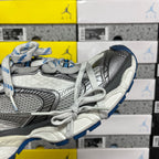 Gray and black lace-up sneaker profile with white laces and blue sole edge