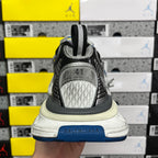 Rear view of gray sneaker with black heel pull tab and blue outsole edge