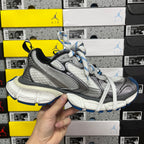 Gray and black lace-up sneaker with blue-striped laces and thick white midsole