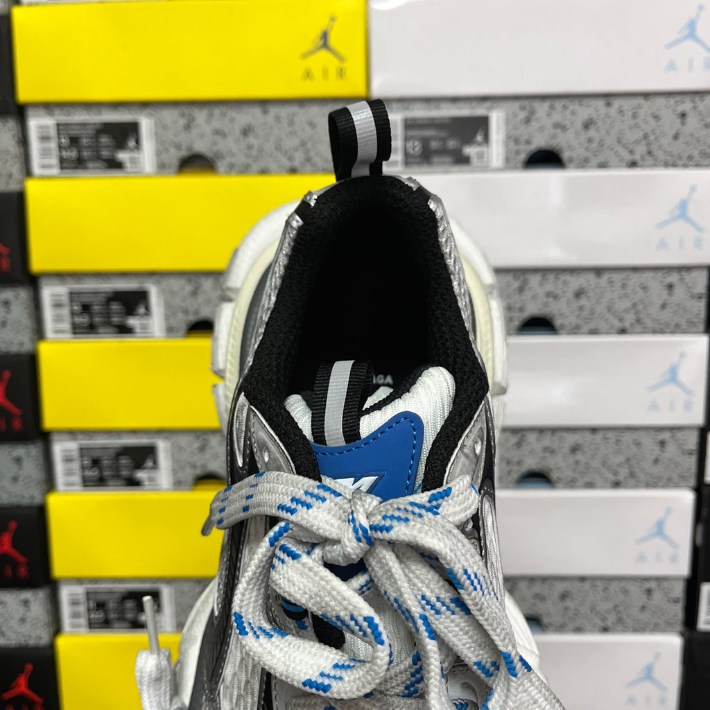 Shoe heel with black collar, gray upper, and blue-accented white laces