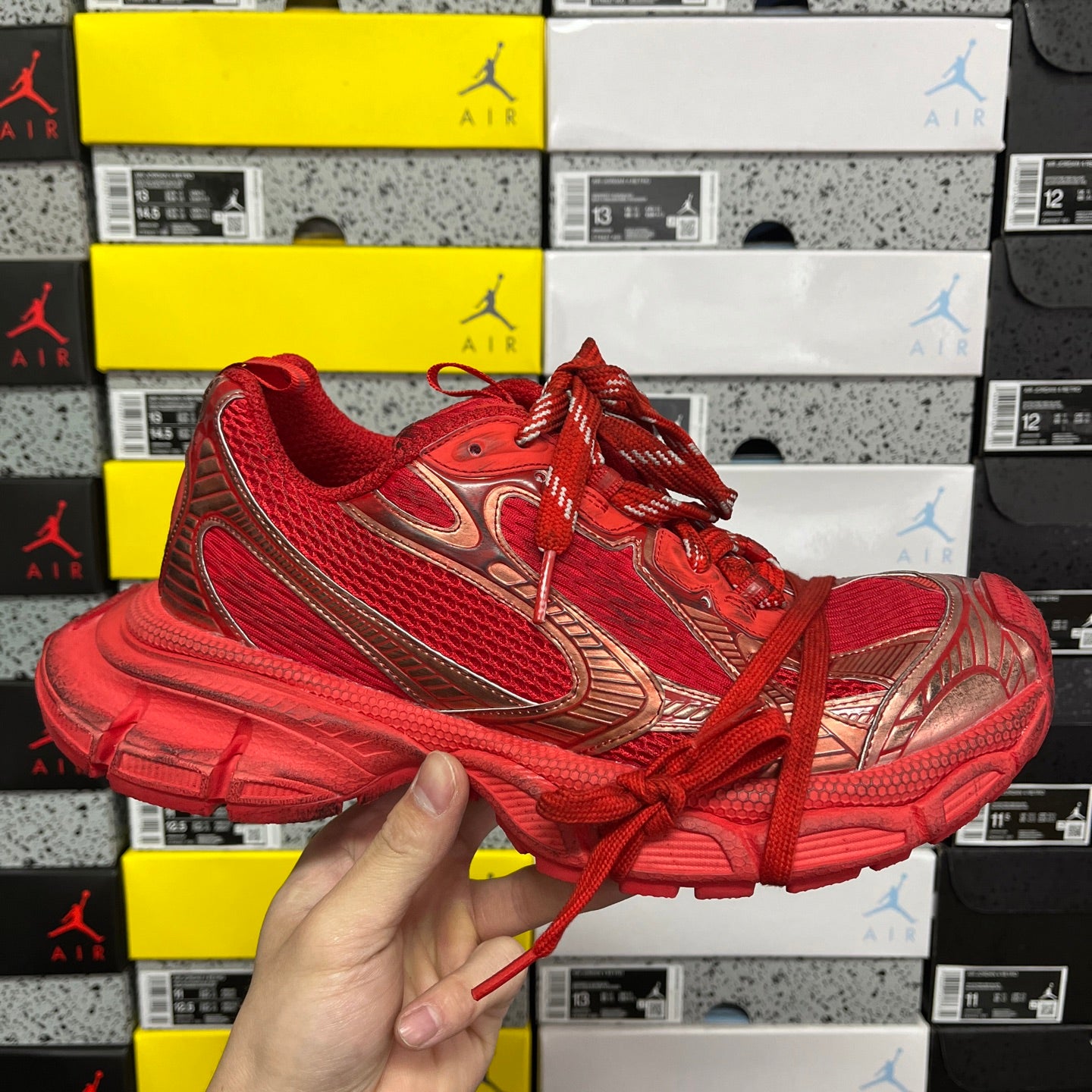 Red lace-up athletic sneaker with gold-toned side stripes and textured upper