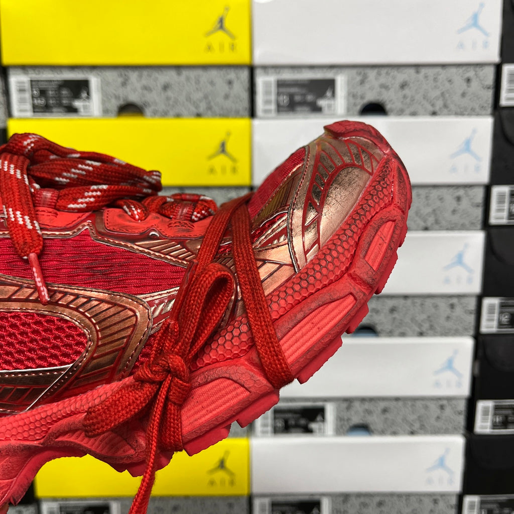 Red sneaker side view with gold-toned overlays and thick running sole