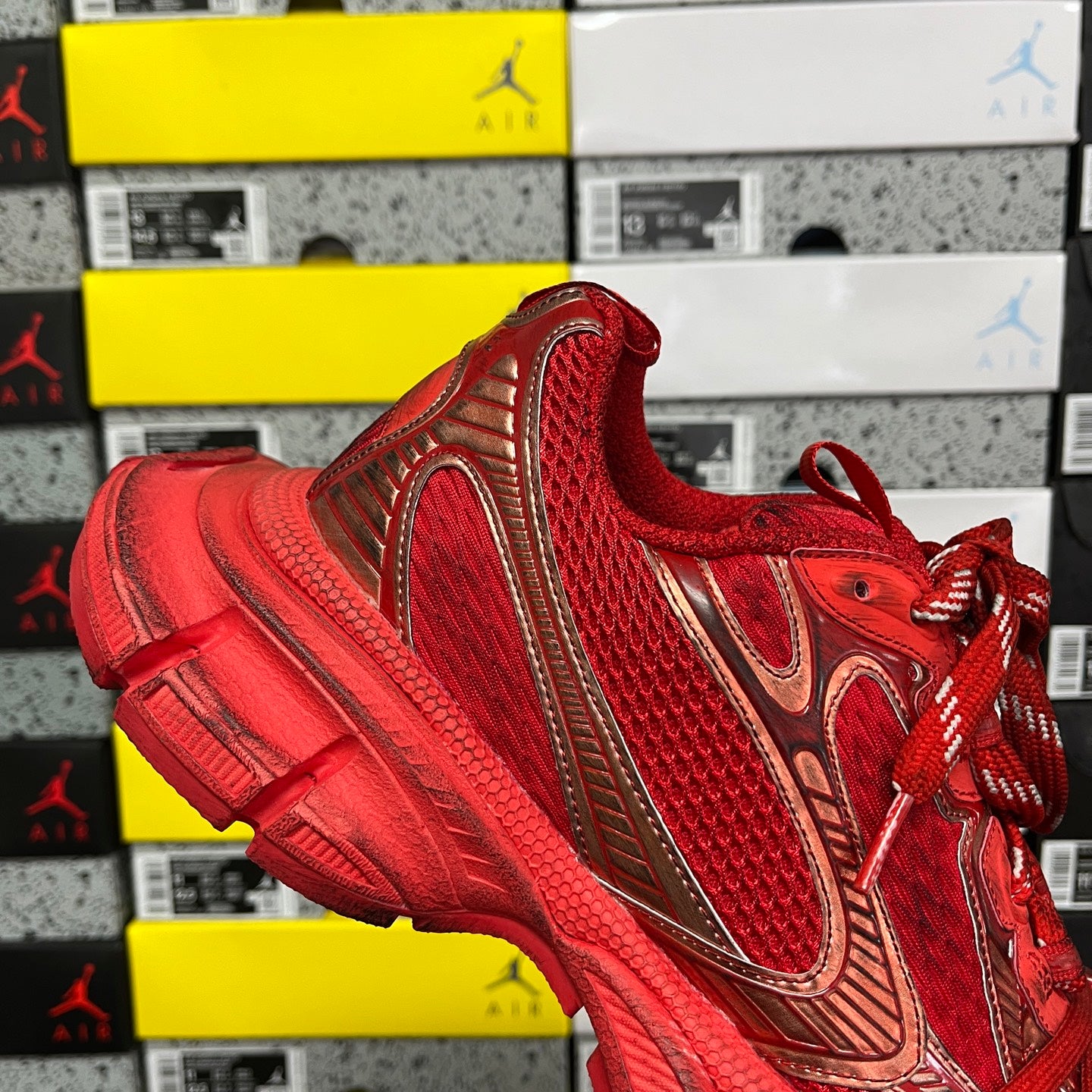 Red lace-up sneaker with gold-toned panel accents and textured toe area
