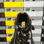 Rear view of black lace-up sneaker with orange-striped loop detail