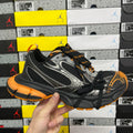 Black, silver and orange low-top sneaker with mesh panels and lace-up closure
