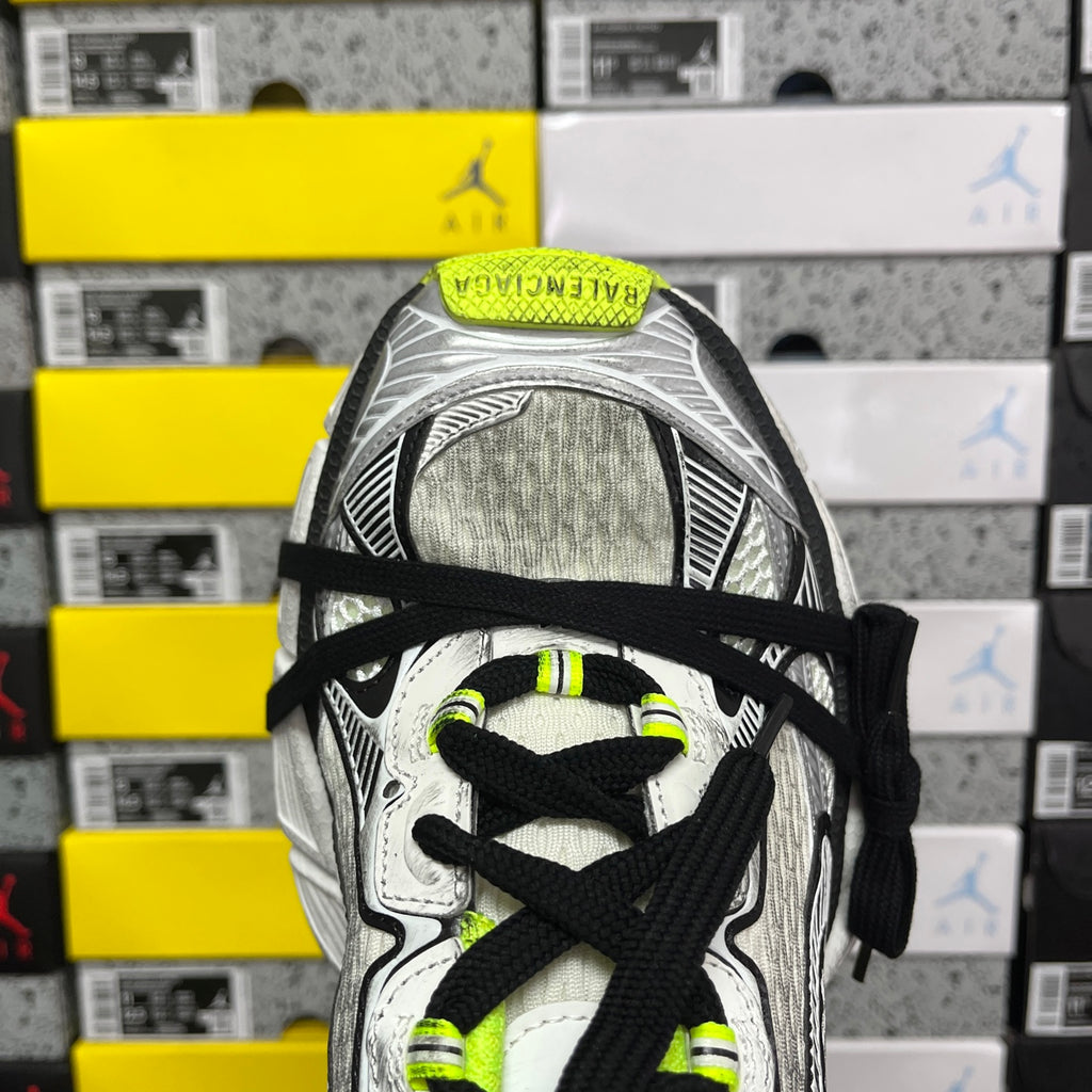 Silver running sneaker with black laces and neon green logo on tongue