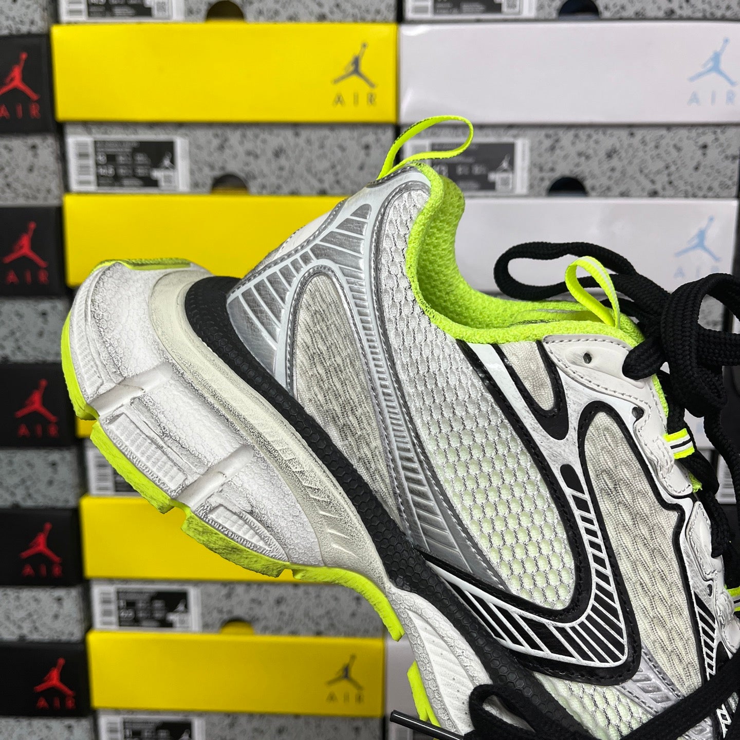 Silver and black running sneaker with neon green heel collar and lace details