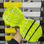 Neon green outsole with grid traction and black stripe detail
