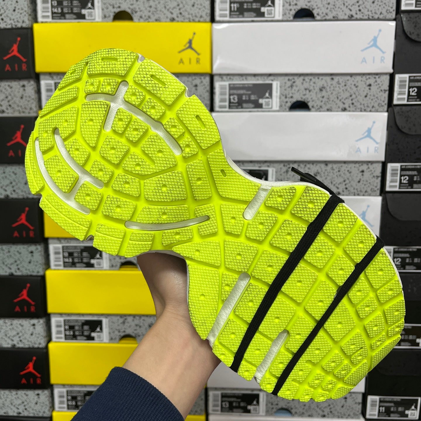 Neon green outsole with grid traction and black stripe detail