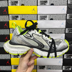 Silver and black lace-up running sneakers with neon green heel and trim